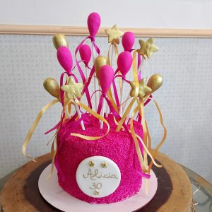 Bolo decorado com granulado rosa e balões de pasta americana